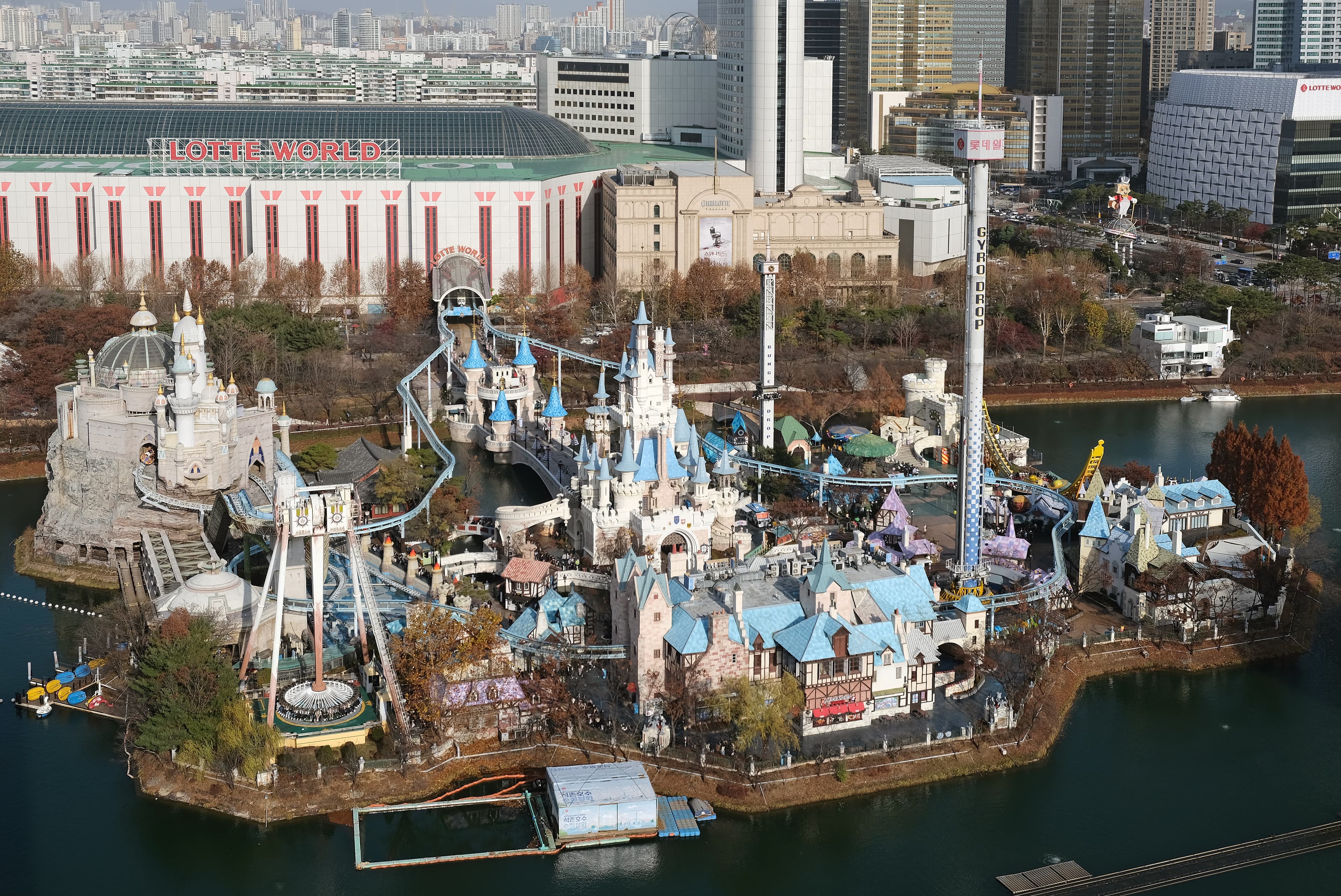Aerial view of Lotte World, showing the indoor Adventure building and the Magic Island castle on the lake