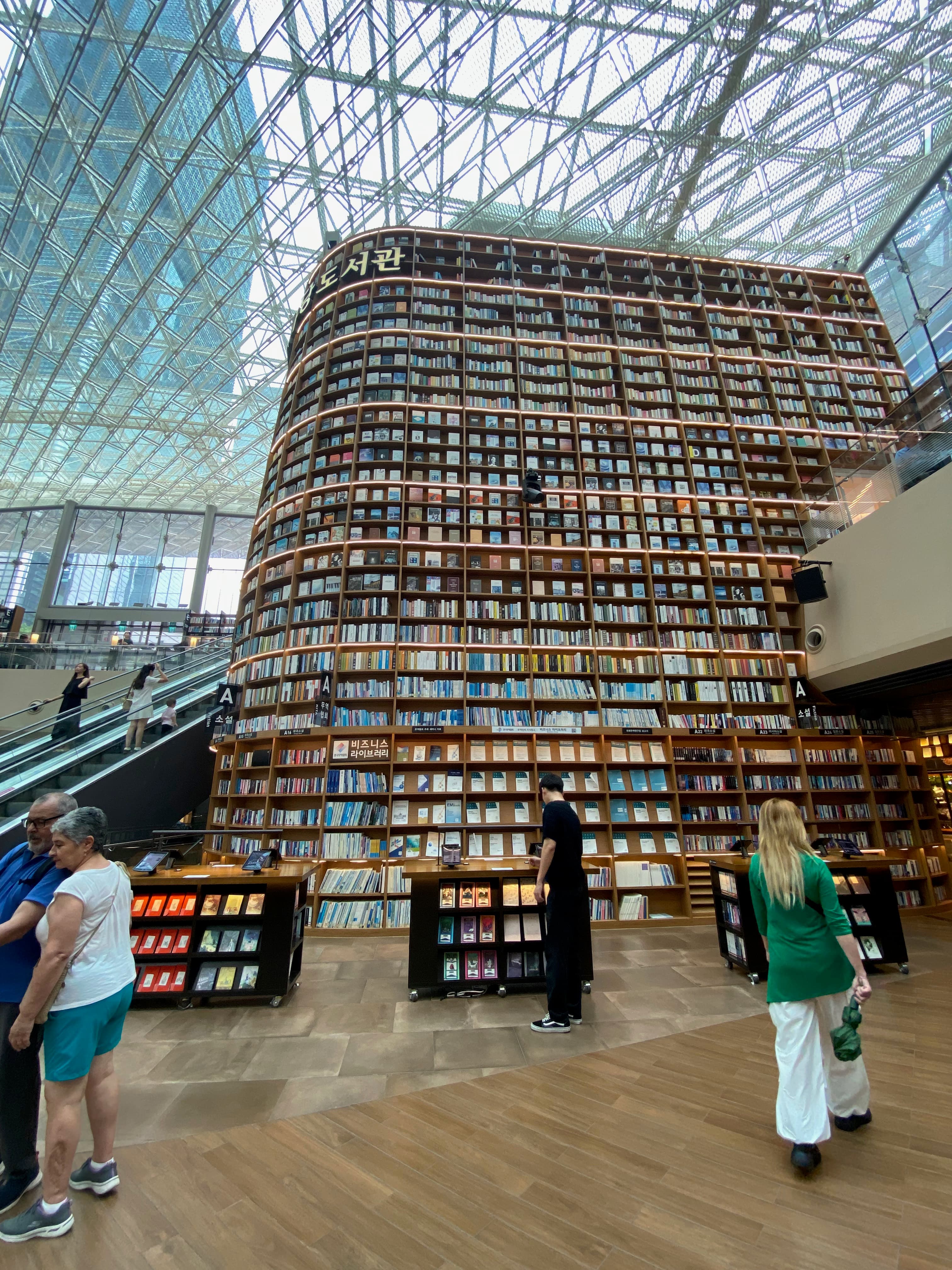 Visitors in front of the floor-to-ceiling bookshelves at Starfield Library