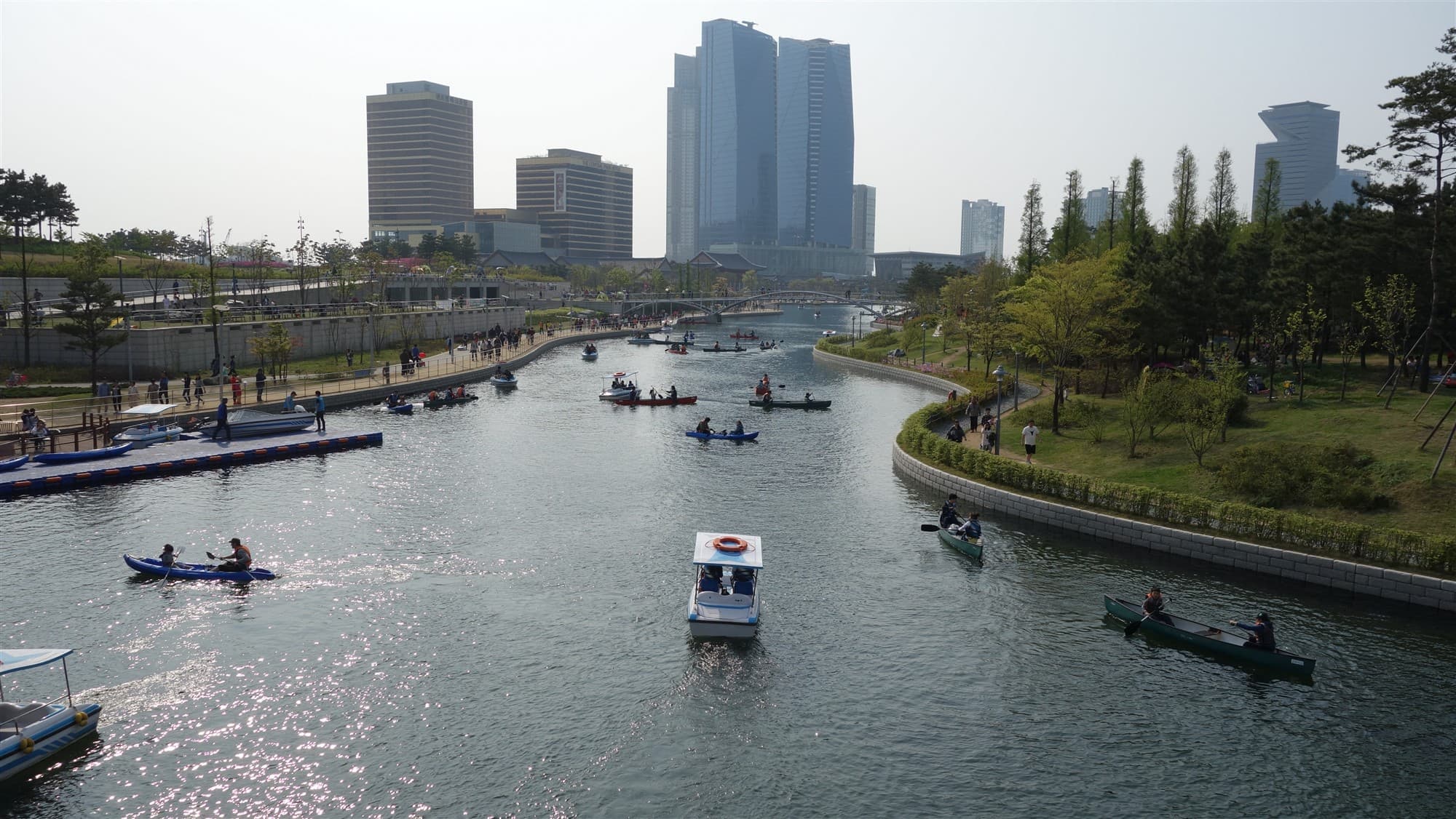Canoes and boats on the Songdo Central Park waterway with the IBD skyline behind