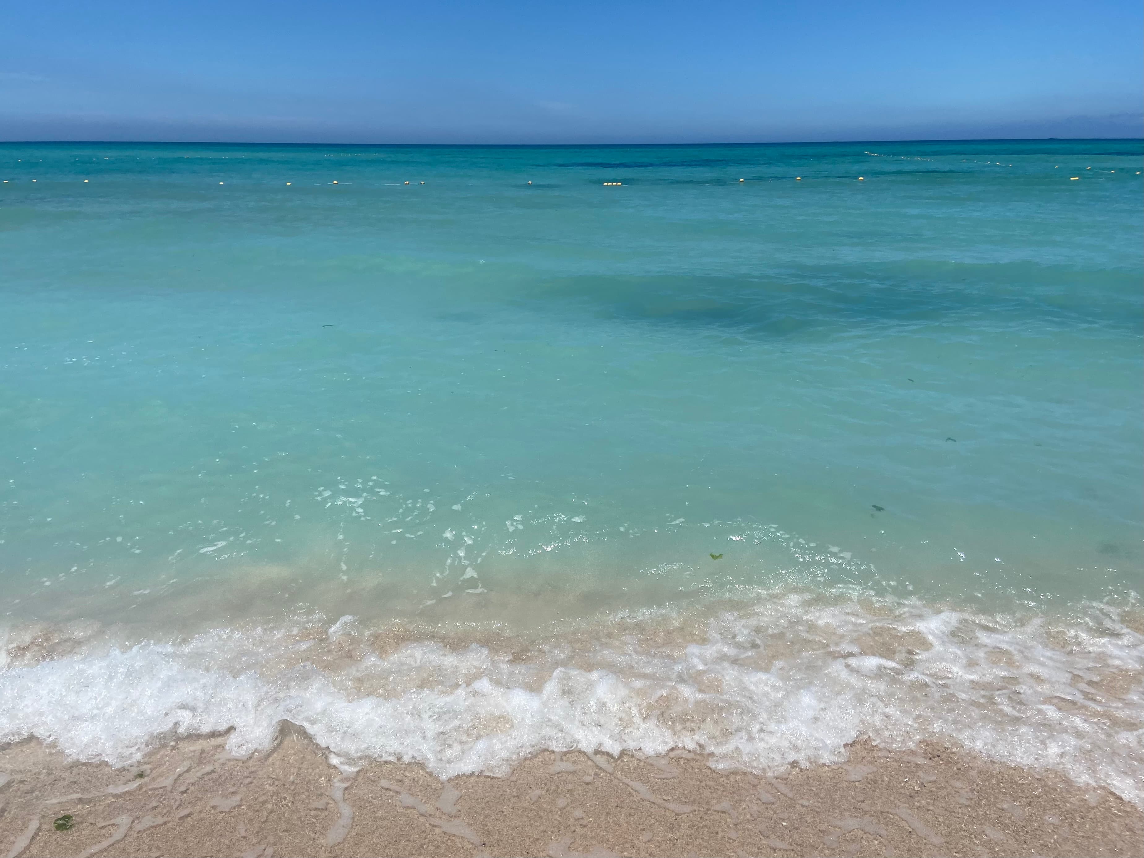 Clear emerald water washing onto the sand at Gwakji Gwamul Beach