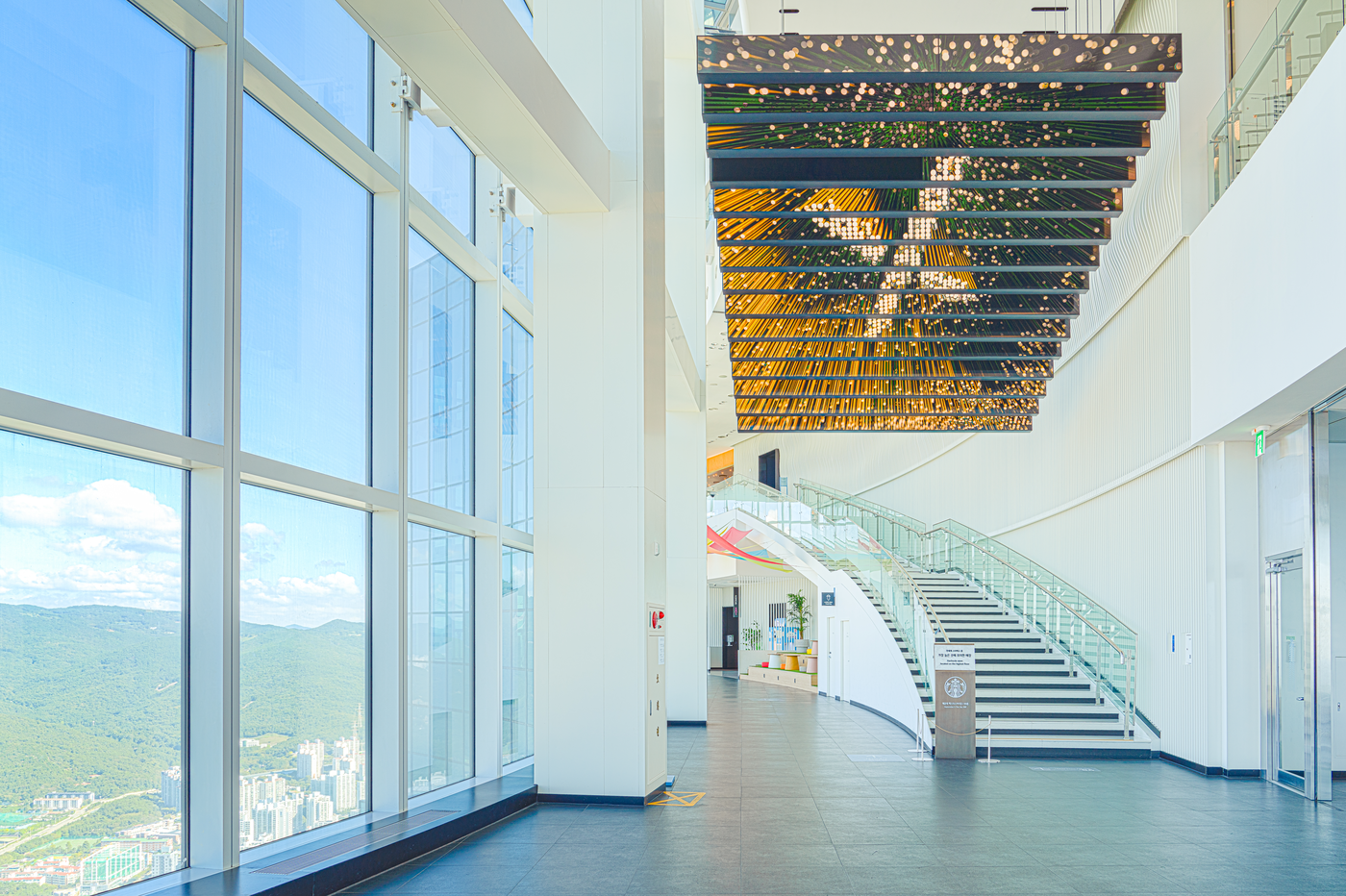 Floor-to-ceiling windows overlooking the Haeundae skyline inside BUSAN X the SKY