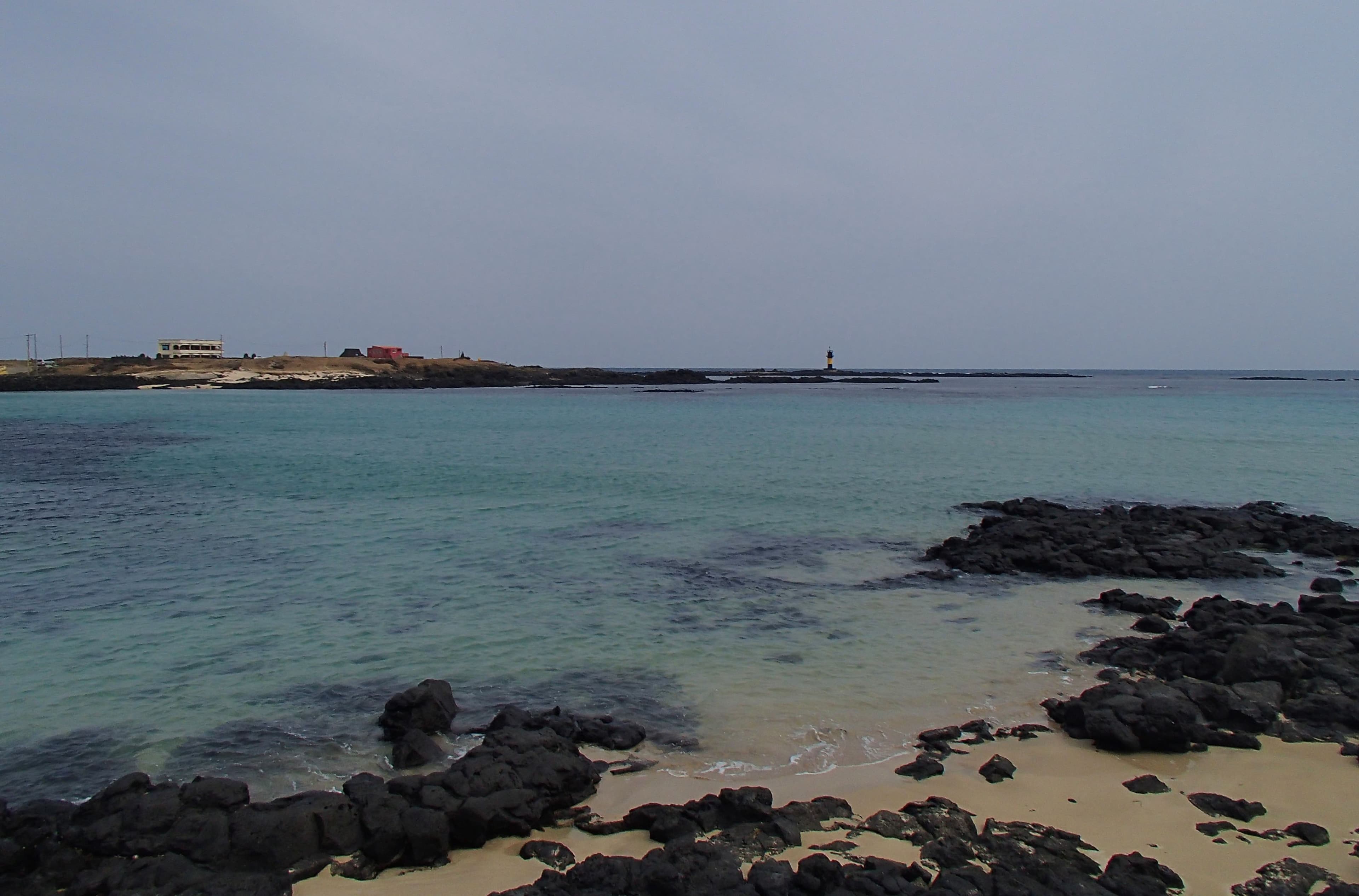 Udo Island's black basalt rocks meeting turquoise water along the coast
