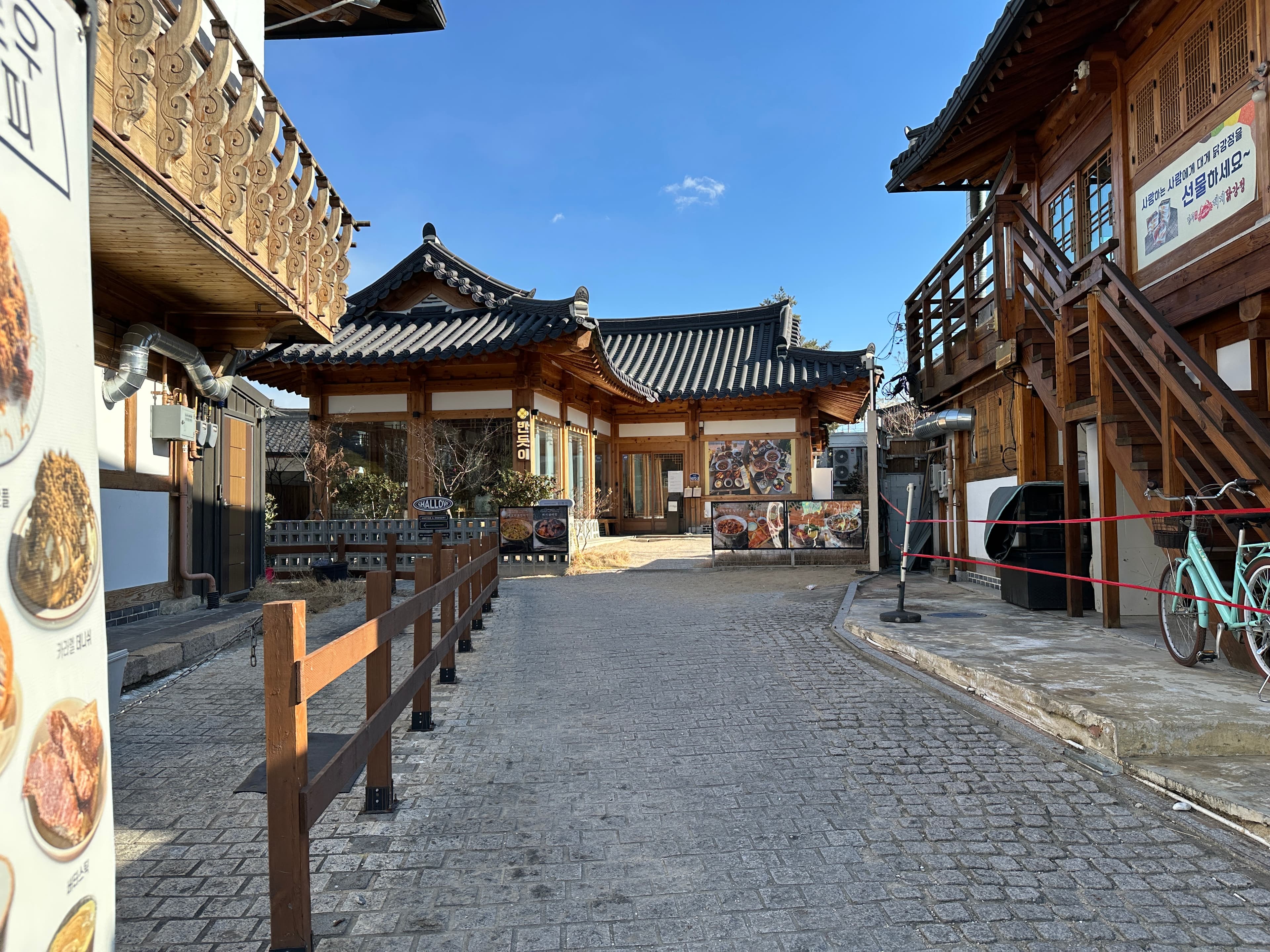 Hanok buildings and menu boards along a Hwangnidan-gil lane