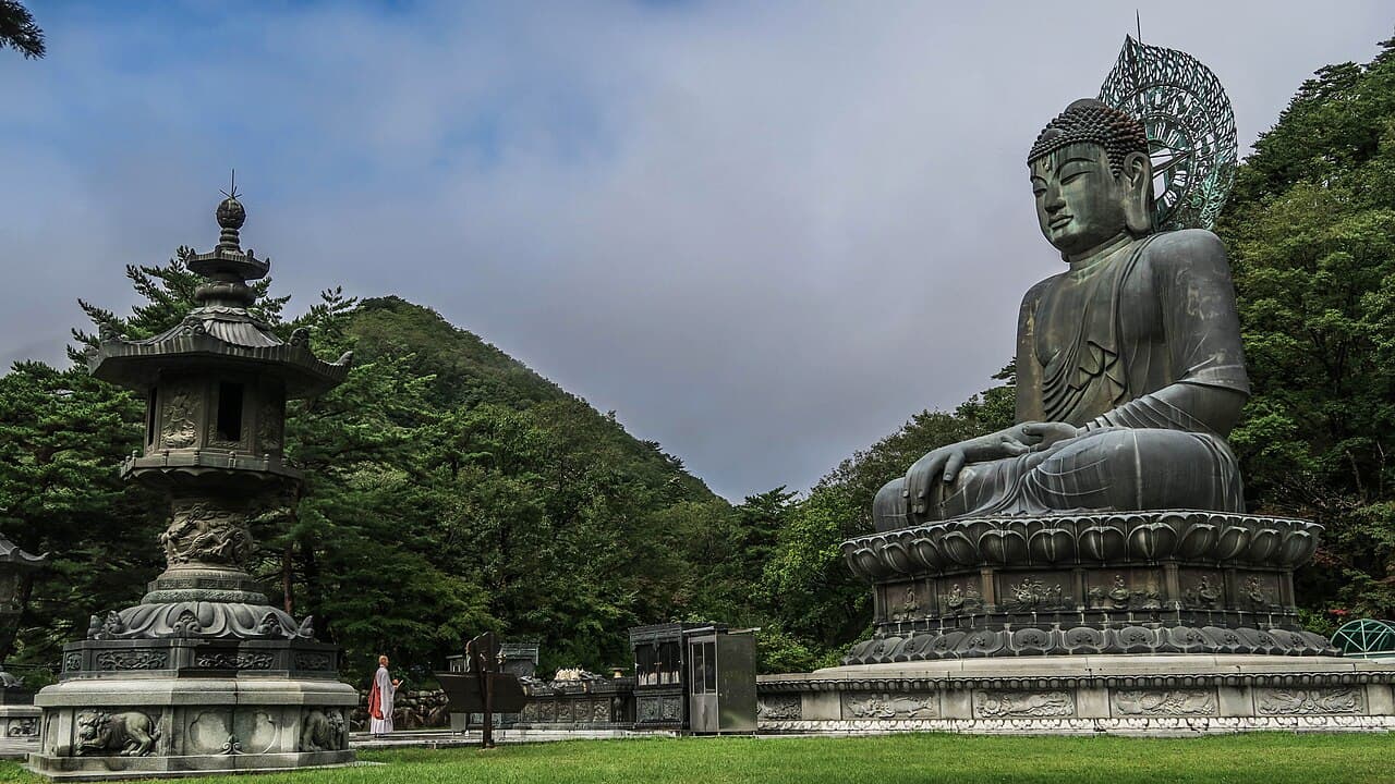 신흥사 진입로의 청동 대불 좌상과 왼쪽의 석등, 그 뒤로 이어지는 설악산 능선