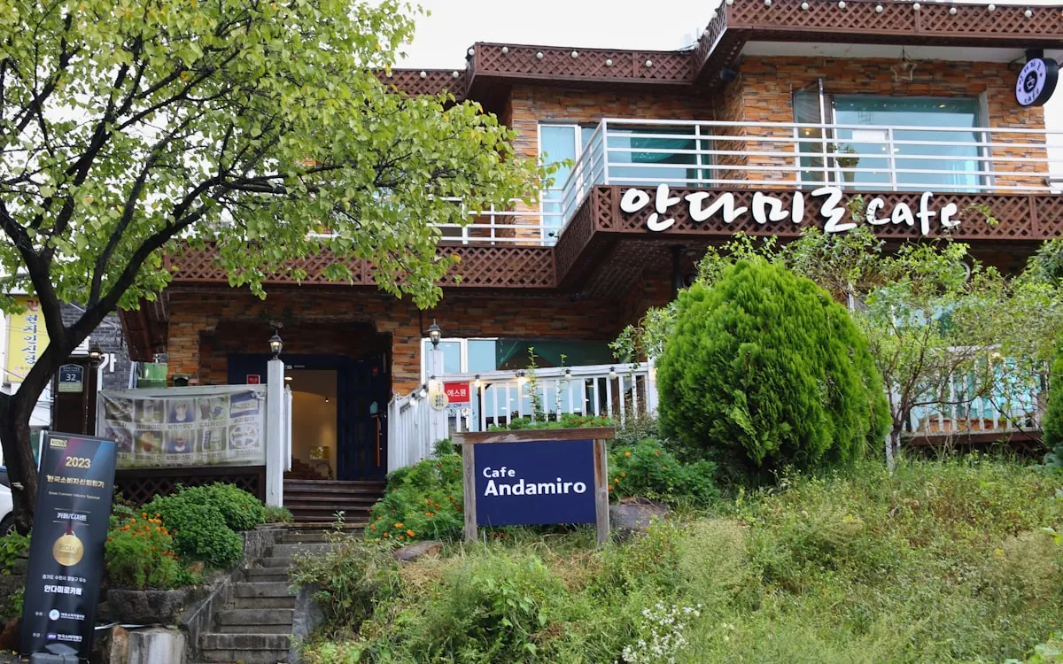 The exterior of a two-storey cafe with an Andamiro cafe sign